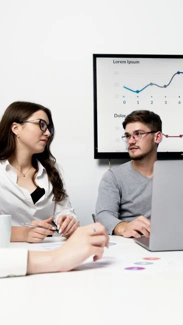 Business professionals working together on financial data analysis in a modern office environment.